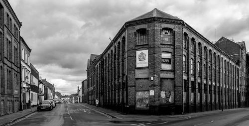 Streets in city against cloudy sky