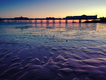 Pier on sea at sunset