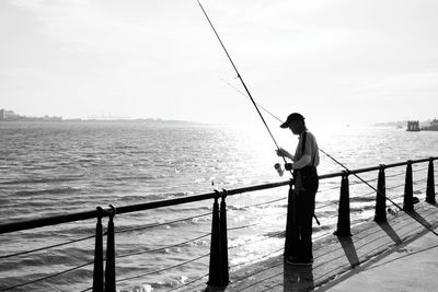 Silhouette of man standing on pier