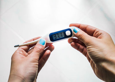 Female hands holding a thermometer