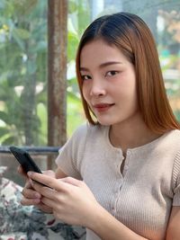 Portrait of young woman using mobile phone