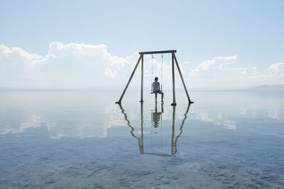 Self portrait on swing set in reflection on salton sea californi