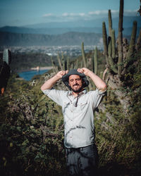 Young man standing by plants on land