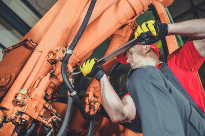 Midsection of man repairing vehicle