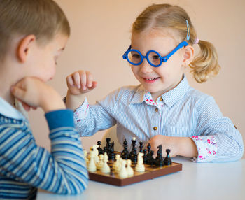 Cute sibling playing chess at home