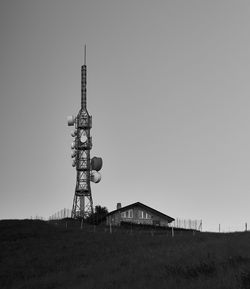 Communications tower on field against clear sky