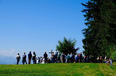 People relaxing on grassy field