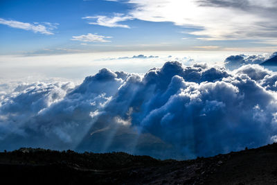 Low angle view of clouds over mountain against sky