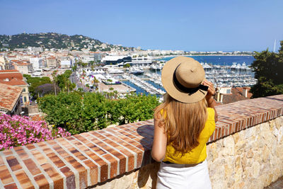 Visiting french riviera. back view of pretty girl enjoying ciyscape of cannes, france.