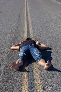 Woman lying down on road