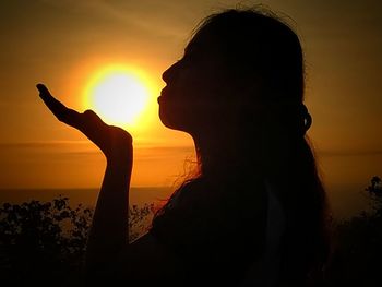 Silhouette woman at beach during sunset
