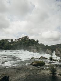 Scenic view of waterfall against sky