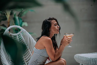 Midsection of a young woman drinking glass