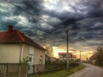 Electricity pylon against cloudy sky