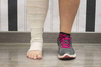 Low section of woman with bandage standing on floor