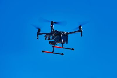 Low angle view of airplane against clear blue sky