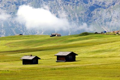 Small house on field against sky