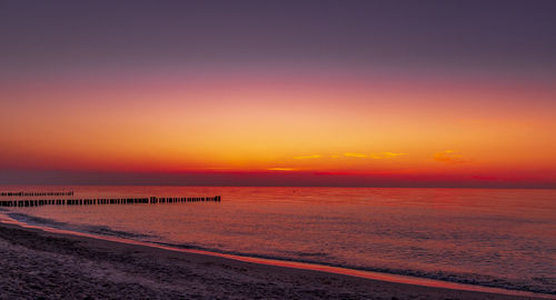 Scenic view of sea against romantic sky at sunset