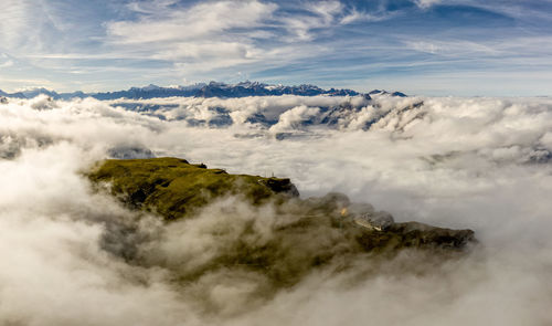 Scenic view of clouds covering mountains against sky