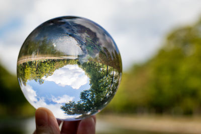 Close-up of hand holding crystal ball with reflection