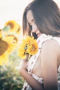 Midsection of woman holding yellow flowering plant