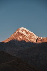 Scenic view of snowcapped mountains against clear blue sky