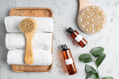 Spa body care concept. anti cellulite cosmetics, wooden brush for dry massaging and white cotton tow