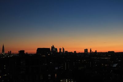 Silhouette buildings against sky during sunset