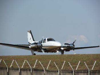 Airplane on airport runway against clear sky