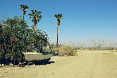 Car on beach against clear sky