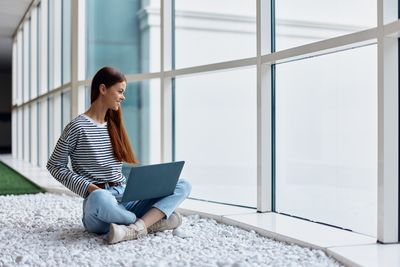 Young man using laptop while sitting on chair