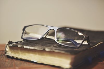 Close-up of eyeglasses with book on table