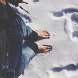 Low section of man standing on snowy land