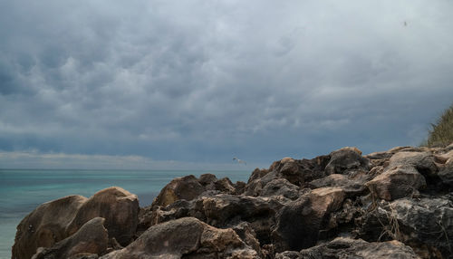 Rocks by sea against sky