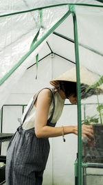 Young asian woman working in a small green house