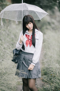 Young woman standing on field during rainy season