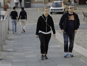 Rear view of people walking on road