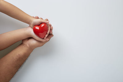 Close-up of hand holding ice cream over white background