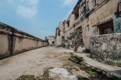 Empty road amidst buildings against sky