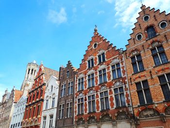 Low angle view of buildings against blue sky in bruges