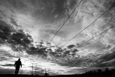 Low angle view of silhouette man standing against sky