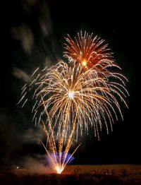 Low angle view of firework display at night