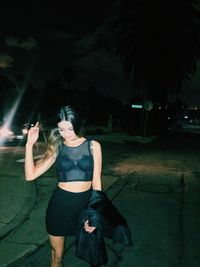 Full length of woman photographing at night