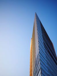 Low angle view of skyscraper against clear blue sky