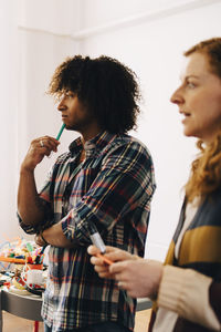 Multi-ethnic technicians looking away while standing at creative office