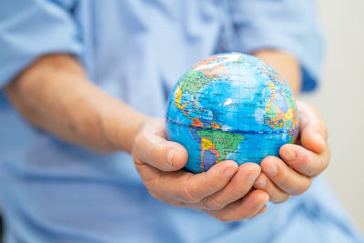 Midsection of man holding globe