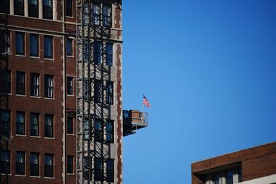 Low angle view of flag against blue sky