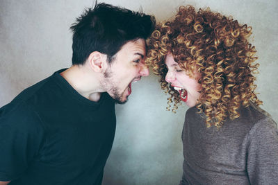 Couple screaming against wall