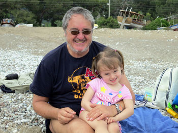 Portrait of smiling father and daughter at beach 