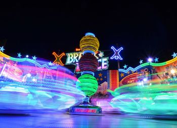 Light trails in amusement park at night